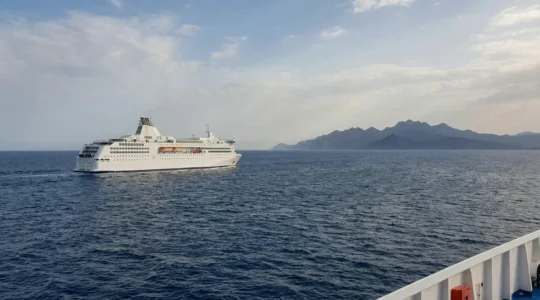 Traghetto in navigazione verso la Corsica nel Mar Tirreno con isola montuosa all'orizzonte